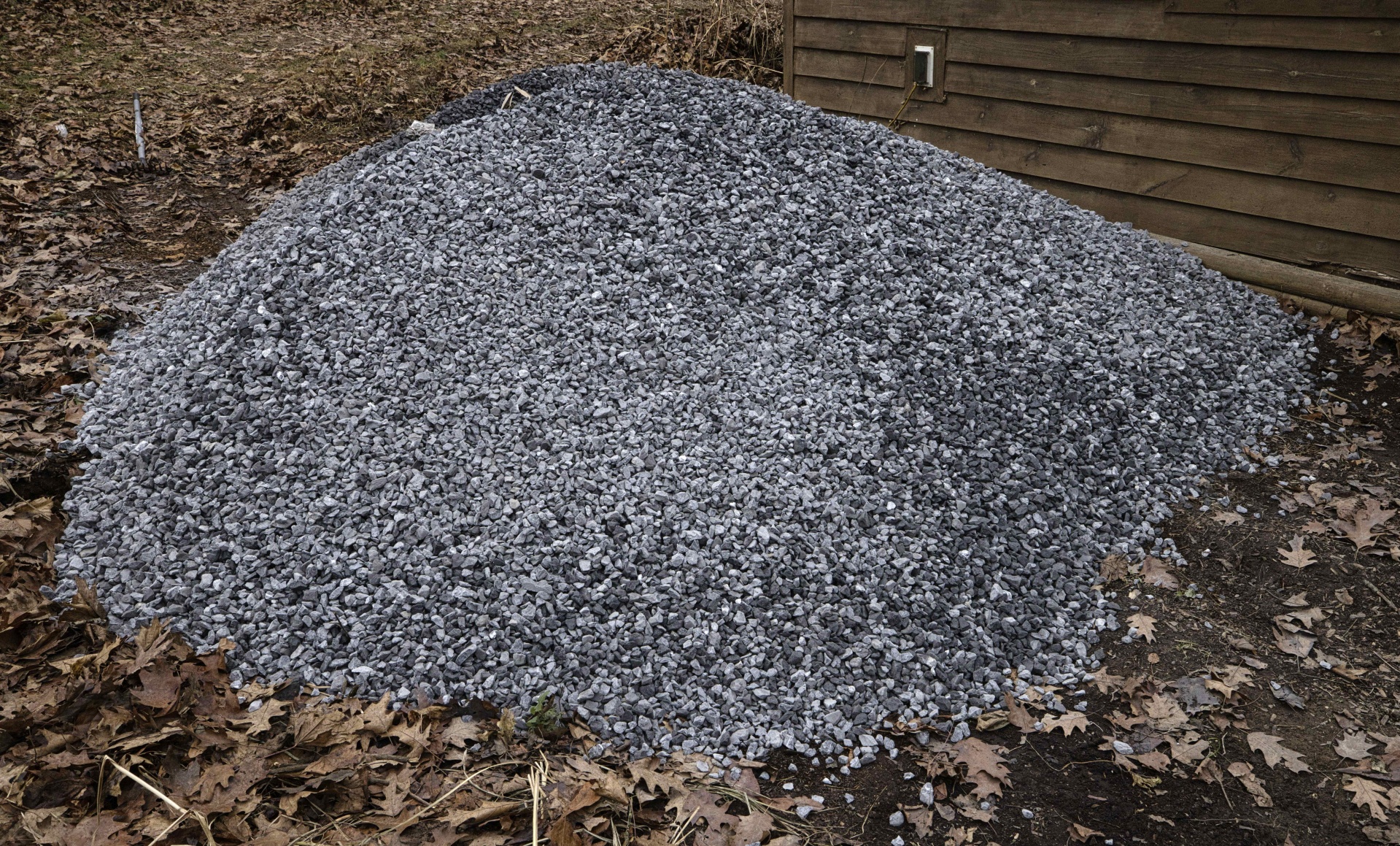 Pile of angular crushed stone beside a building