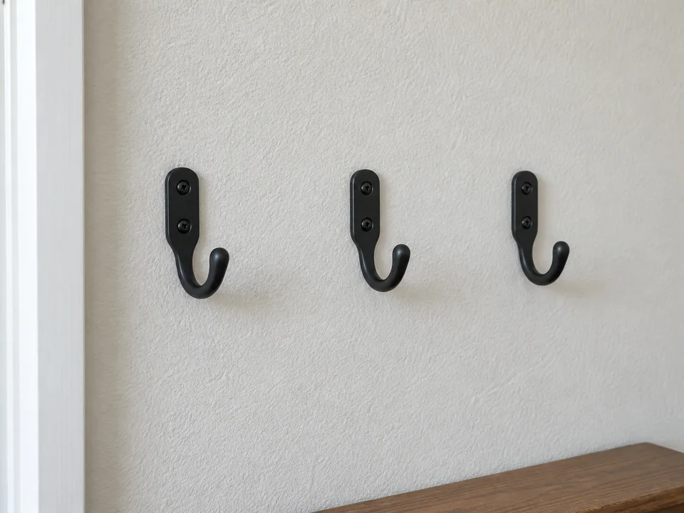 Three coat hooks installed neatly in an entryway