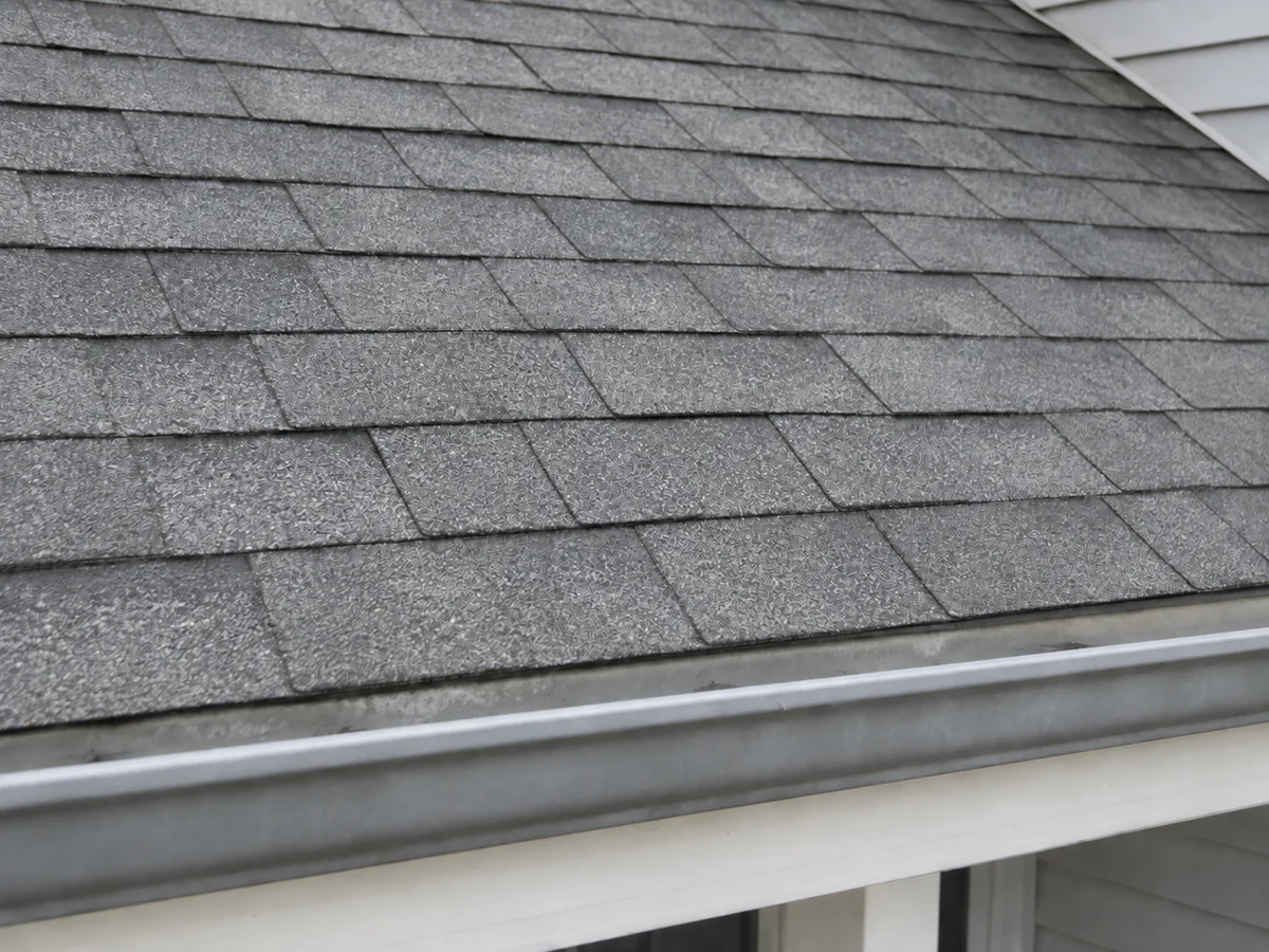 Repaired gray shingles above the porch